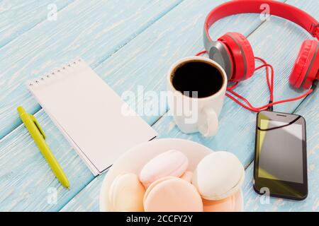 Il marshmallow è accanto al telefono e le cuffie rosse e una tazza di caffè nero. Pausa caffè. Musica piacevole. Foto Stock