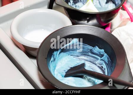 Tintura per capelli in ciotole e spazzola per colorare i capelli. Foto Stock