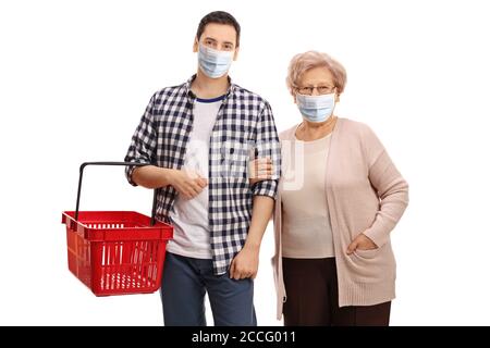 Giovane con un cestino vuoto e un anziano donna che indossa maschere facciali di protezione isolate su sfondo bianco Foto Stock