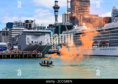 Porto di Auckland, Nuova Zelanda. Un uomo in una barca gonfiabile lascia un fumo flare per simulare un'emergenza, guardato da una grande folla. 1/26/2019 Foto Stock