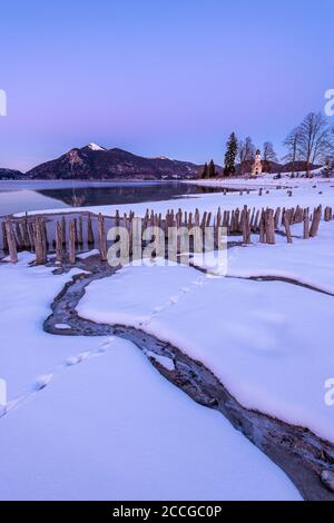 La piccola cappella di San Margareth, Jochberg sullo sfondo e in primo piano le antiche tavole di legno di una storica fattoria di pesce o gamberi su t Foto Stock