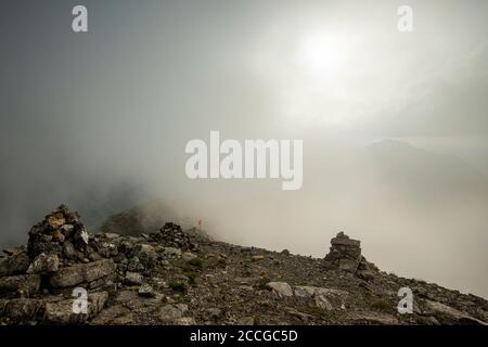 Due alpinisti hanno raggiunto la vetta del Sonnjoch nel Karwendel, le Alpi Tirolo dopo 1700 metri di altitudine e quasi 12 ore di salita in nebbia fitta Foto Stock