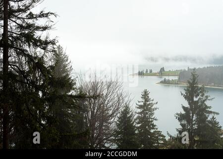 Nuvole e nebbia sulla penisola di Zwergern nel Walchensee, visto dal sentiero per Herzogstand Foto Stock