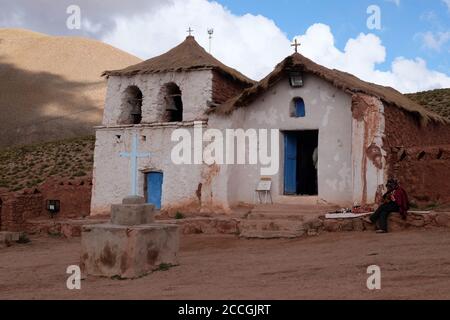 Il musicista indiano andino intrattiene i turisti visitando la chiesetta di Machuca alta nelle ande cilene. Foto Stock