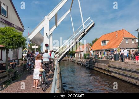 Pedoni e motociclisti in attesa di ponte aperto per il passaggio di yacht Foto Stock