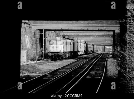 Una locomotiva elettrica di classe 85 numero 85108 che lavora un treno di trasporto di automobile caricato formato da Silcock Cartic-4 insiemi e furgoni che si avvicinano a Caledonian Road e Barnsbury sulla linea di Londra del nord il 14 marzo 1991. Foto Stock