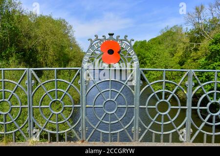 Primo piano del ponte in ghisa di Coalport, costruito nel 1818, con un ricordo di popy che attraversa il fiume severn nello Shropshire contro il cielo blu nuvoloso in estate Foto Stock