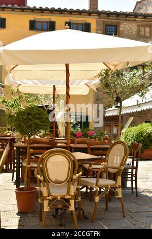 Grazioso tavolo da caffè desertato e sedie con ombrellone bianco in, Montecatini Alto, strada italiana Foto Stock