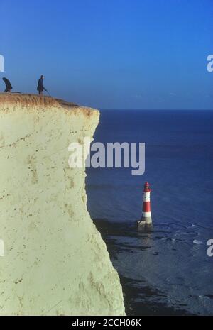 La gente vicino al bordo della scogliera vicino al faro di Beachy Head. South Downs. Sussex orientale. Inghilterra. REGNO UNITO Foto Stock