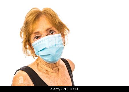 Donna anziana che indossa maschera facciale durante l'epidemia di Corona Virus Foto Stock