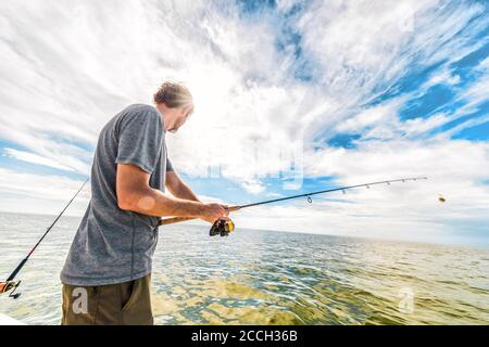 Pesca in Everglades, Florida USA viaggio di vacanza estiva. Uomo turistico pesca in mare da barca gettando linea esca Foto Stock