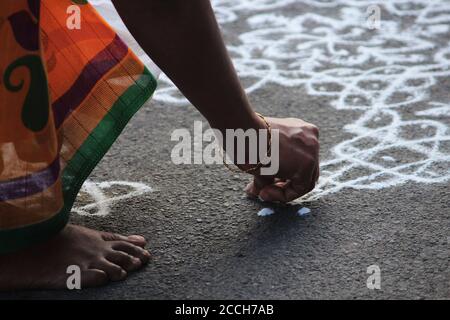 Donna sudindiana disegnando kolam e rangoli nel concorso Mylapore Kolam, Chennai Foto Stock