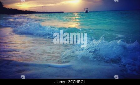 Onde al tramonto alle Maldive Foto Stock