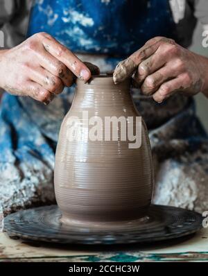 Mani di vasaio che fanno in creta su ruota di ceramica. Potter fa sulla ruota di ceramica Foto Stock