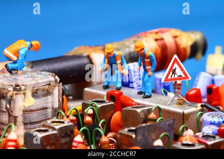 Addetto alla lavorazione in miniatura che ispeziona una radio a circuito stampato vintage concetto di riparazione Foto Stock