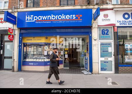 Slough, Berkshire, Regno Unito. 22 agosto 2020. Un uomo cammina oltre un negozio di Pawnbrokers. Slough in Berkshire è stato nominato dal Public Health England e dal Department for Health and Social Care come una "area di preoccupazione" del Covid-19 a seguito di un recente aumento del numero di casi. Credito: Maureen McLean/Alamy Foto Stock