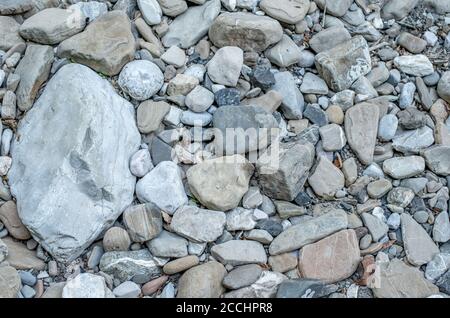 Sfondo di pietre sporche e ciottoli sul lato del fiume Foto Stock