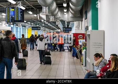 Londra, Regno Unito - 05 febbraio 2019: Passeggeri che camminano fino al cancello d'imbarco, alcuni seduti in attesa, all'aeroporto di Luton. LTN è il quinto paese con 1 Foto Stock