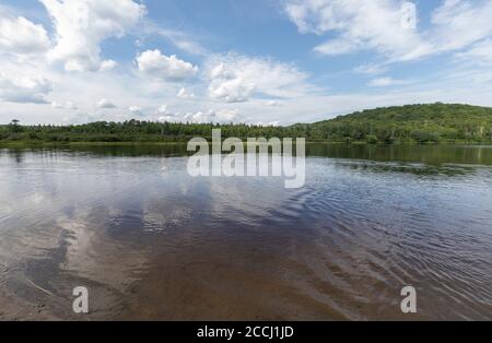 Cielo blu con nuvole bianche riflesse in acqua ferma a. un parco tranquillo in una giornata estiva Foto Stock