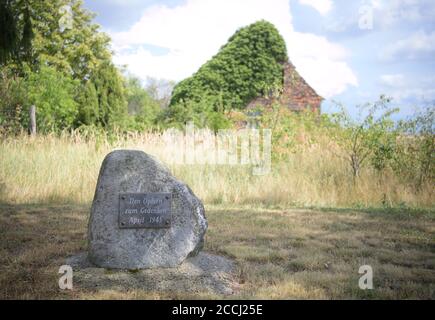 18 agosto 2020, Brandeburgo, Niedergörsdorf/ OT Oehna: Una pietra con l'iscrizione 'in memoria delle vittime. Aprile 1945' è scritto su un prato di fronte alle rovine di una casa alla stazione. Il villaggio sul bordo del Fläming è stato menzionato per la prima volta in una lettera da un vescovo nel 1161. Il villaggio si trova vicino alla città di Jüterbog sulla Fläming-Skate ed è anche una destinazione popolare per escursioni grazie alla sua piscina all'aperto e campeggio. Foto: Soeren Stache/dpa-Zentralbild/ZB Foto Stock