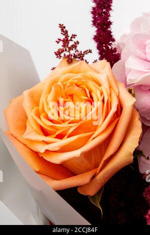 Bel bouquet con morbido rosa Hydrangea (Hydrangea macrophylla) o Hortensia fiore, rosa arancio mite e carta da imballaggio rossa. Sensazione di morbidezza da sogno Foto Stock