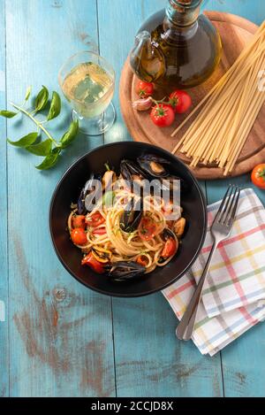 Piatto di deliziosi spaghetti con pomodori ciliegini e salsa di cozze, un tipico cibo italiano Foto Stock