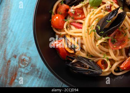 Piatto di deliziosi spaghetti con pomodori ciliegini e salsa di cozze, un tipico cibo italiano