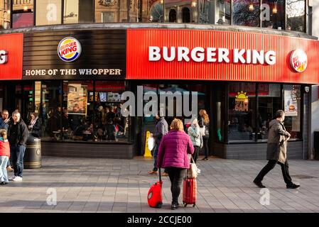 Affollato vista urbana di persone turisti e visitatori al di fuori del Burger King fast food outlet ristorante facciata rossa a Leicester Square West End, Londra, Regno Unito Foto Stock