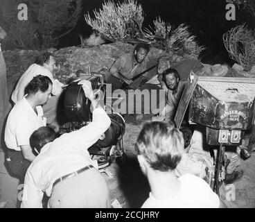 HUMPHREY BOGART WALTER HUSTON e TIM HOLT sul set candid con la squadra di film compreso JOHN HUSTON (parzialmente nascosto sotto la luce del film) che filma IL TESORO DEL regista / sceneggiatura DELLA SIERRA MADRE 1948 JOHN HUSTON romanzo B. Traven Warner Bros. Foto Stock