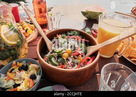 Primo piano della ciotola con insalata di verdure fresche sul tavolo per la cena all'aria aperta Foto Stock