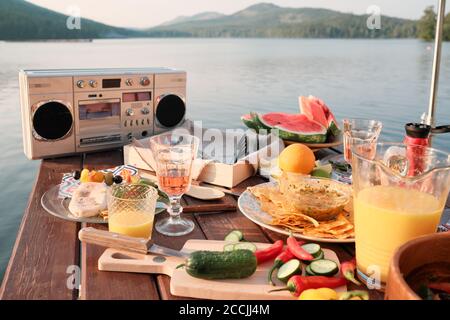 Immagine del tavolo da pranzo con spuntini, frutta e succo di frutta la festa su un molo all'aperto Foto Stock