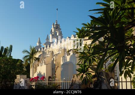 Chiesa dell'Apostolo 'Parroquia de Santiago Apostol' con piante tropicali durante l'ultimo sole, vecchia chiesa cattolica romana con campanile decorato a Merida, Yu Foto Stock