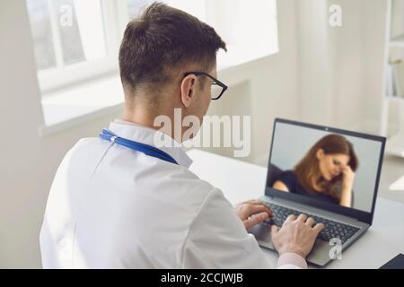 Doctor online.Telemedicine.Medical conferenza online.Man medico utilizza un computer portatile e ascolta un paziente. Foto Stock