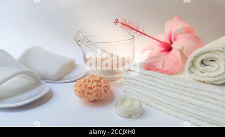 Ambiente Spa e composizione di sfondo Spa con fiore rosa ibisco su sfondo bianco. Banner. Spazio di copia. Asciugamano, candele, fiori, pietre. Massa Foto Stock