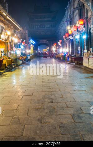 Popolo fantasma vagare attraverso le antiche strade intorno alla torre di città in Pingyao, nella provincia di Shanxi, Cina Foto Stock