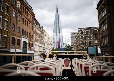 I turisti su un ponte vicino vuoto sul Big Bus di Londra con tour scoperto mentre passa vicino allo Shard di Londra. Foto Stock