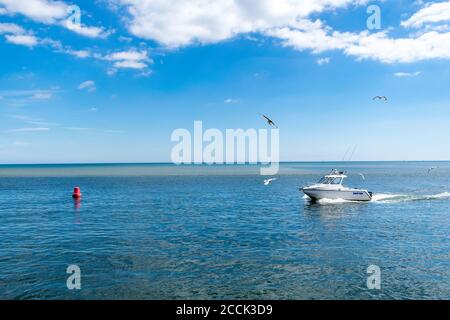 Mudeford Quay, Regno Unito - 16 luglio 2020: Motoscafo a Mudeford Quay, uomo che guida piccole barche a motore durante il giorno di sole e bel tempo caldo Foto Stock