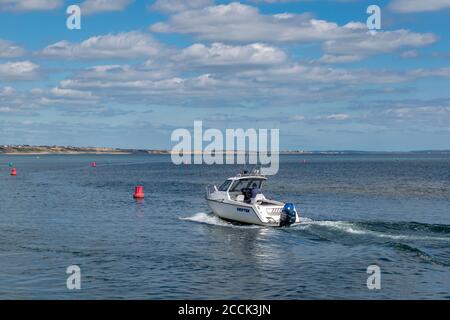 Mudeford Quay, Regno Unito - 16 luglio 2020: Motoscafo a Mudeford Quay, uomo che guida piccole barche a motore durante il giorno di sole e bel tempo caldo Foto Stock