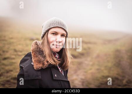 Ritratto di una donna in un paesaggio foggoso Foto Stock