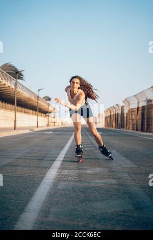 Giovane donna pattinaggio sul Boardwalk presso la costa Foto Stock