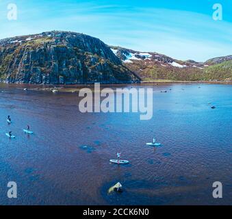 Russia, Oblast di Murmansk, distretto di Kolsky, Teriberka, surfisti SUP sul fiume Teriberka, vista aerea Foto Stock