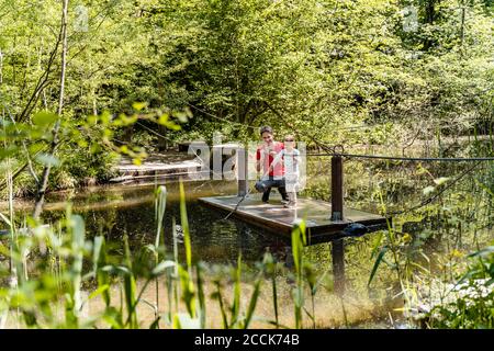 Padre e figlia su zattera di legno sul lago nella foresta Foto Stock