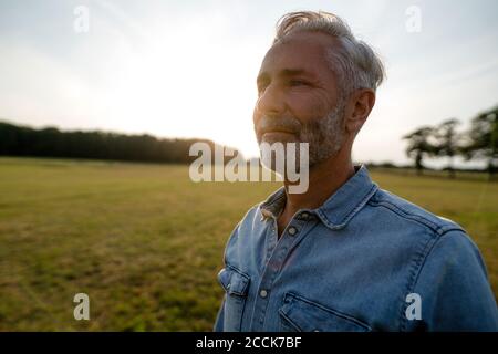 Contenuto uomo maturo su un prato in campagna Foto Stock