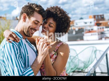 Romantica coppia multietnica che danzano sul patio dell'attico Foto Stock