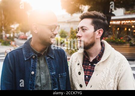 Primo piano di una coppia gay che si guarda l'un l'altro mentre si è in piedi in città Foto Stock