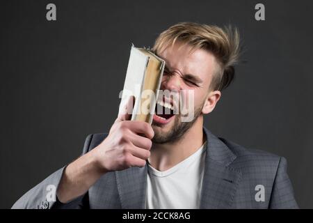 L'uomo batte faccia con il libro, la motivazione. Uomo d'affari arrabbiato gridando con libro, conoscenza. Motivazione, successo di potere. Conoscenza, informazione, saggezza. Formazione, studio di apprendimento Biblioteca lettura della letteratura Foto Stock