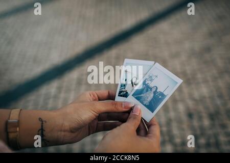 Primo piano di mani femminili che tengono fotografie all'aperto Foto Stock