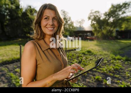 Giovane donna che usa la tavoletta in campagna Foto Stock