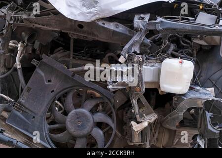 L'auto si schiaccia. Vista frontale ravvicinata di un'auto distrutta. Auto dopo una collisione frontale. Cofano piegato e parti rotte Foto Stock