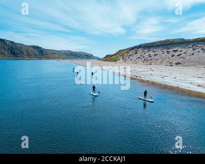 Russia, Oblast di Murmansk, distretto di Kolsky, Teriberka, surfisti SUP sul fiume Teriberka, vista aerea Foto Stock